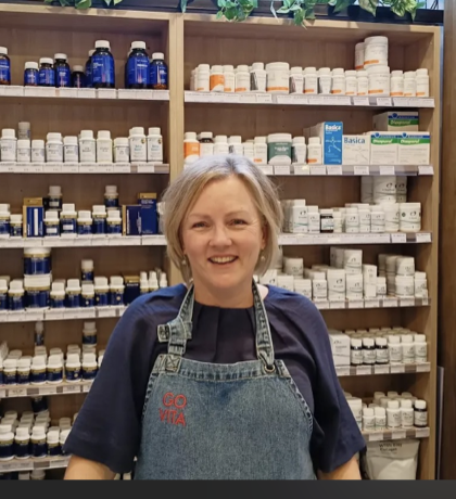 Jenni, naturopath at Go Vita Midland, in front of the practitioner supplement wall